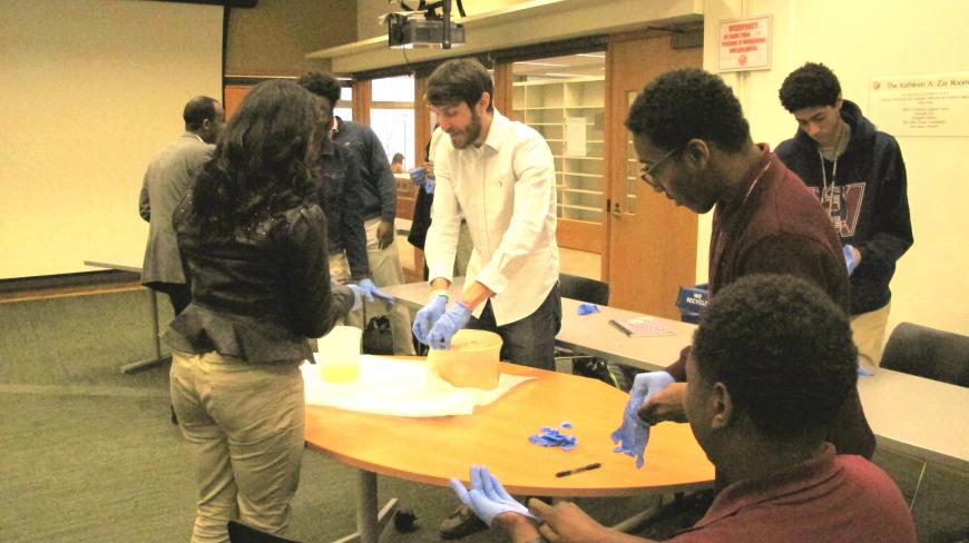 Matt Best shows students rhesus and human monkey brains.