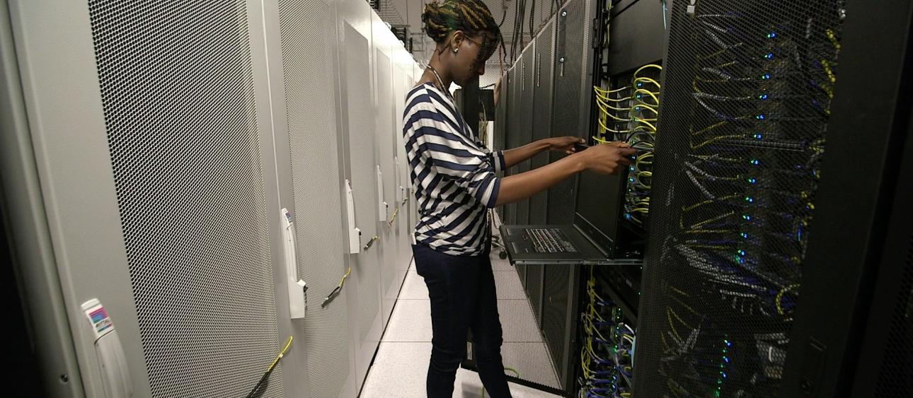 Research Computing Center system administrator Hellen Nyatsambo puts finishing touches on the Midway2 high-performance computing cluster. Photo by UChicago Creative staff.